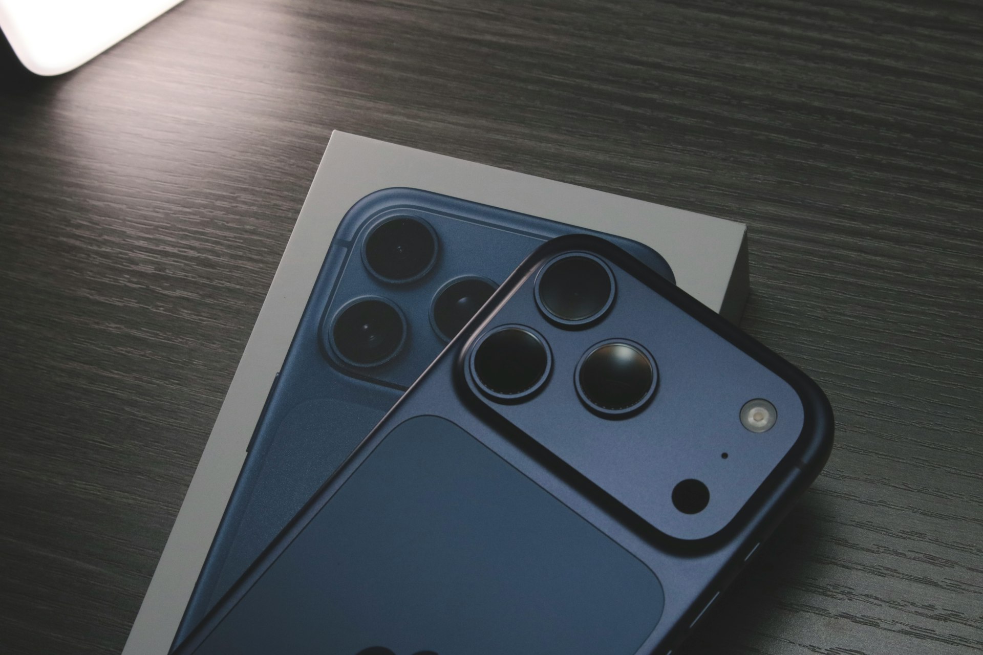 Blue smartphone with three rear cameras on box